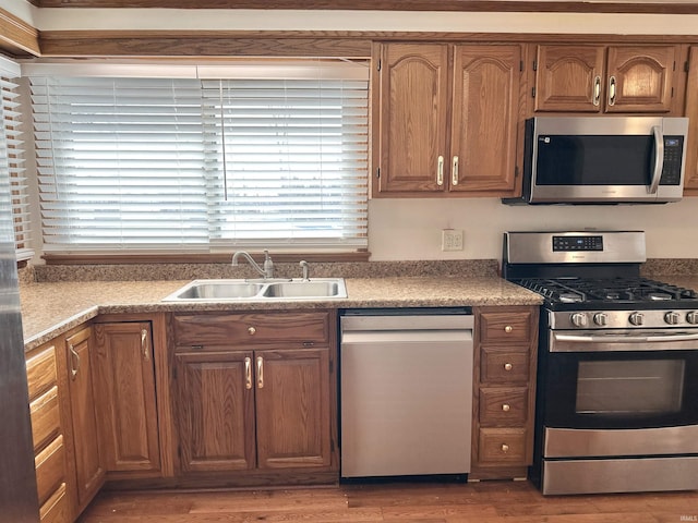 kitchen featuring appliances with stainless steel finishes, hardwood / wood-style flooring, and sink