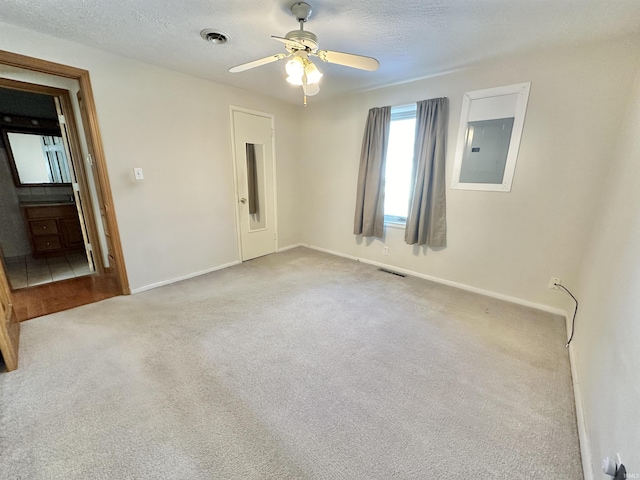 carpeted empty room featuring a textured ceiling, electric panel, and ceiling fan