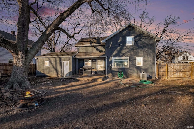 back house at dusk with central air condition unit