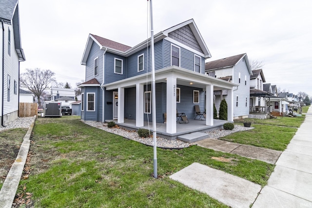 rear view of house with covered porch and a yard