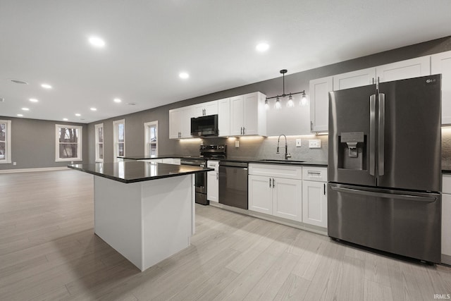 kitchen with sink, hanging light fixtures, decorative backsplash, white cabinetry, and stainless steel appliances