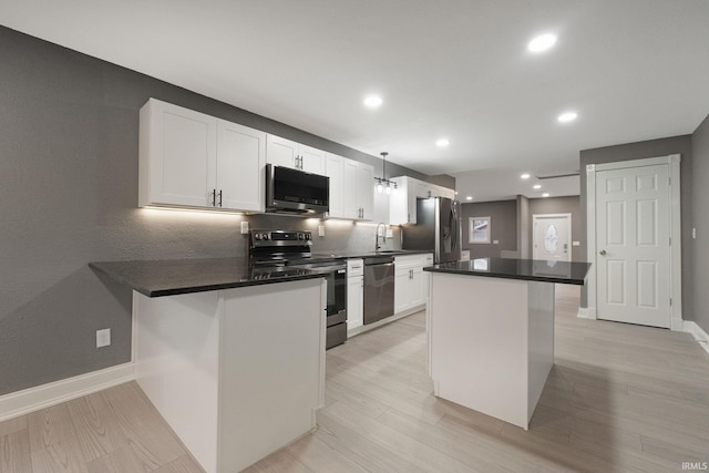 kitchen featuring white cabinets, a kitchen breakfast bar, a center island, and appliances with stainless steel finishes