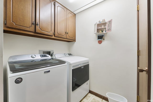 washroom featuring washing machine and dryer and cabinets