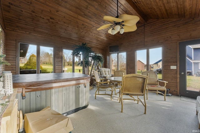 sunroom with a healthy amount of sunlight, a jacuzzi, ceiling fan, and lofted ceiling with beams