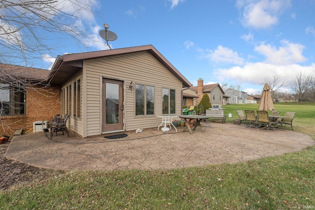 rear view of house with a patio area and a yard