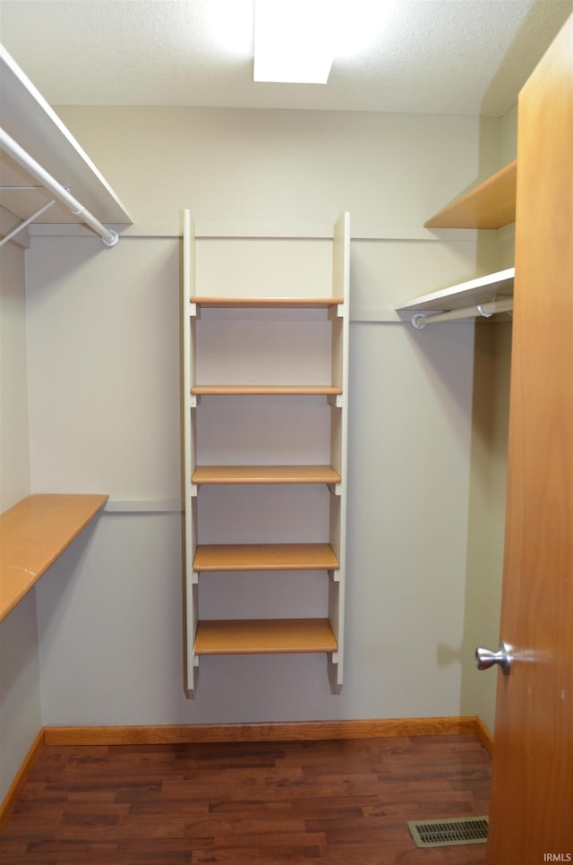 spacious closet with dark wood-type flooring