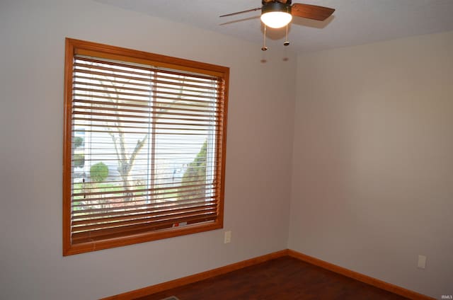 spare room with ceiling fan and dark wood-type flooring