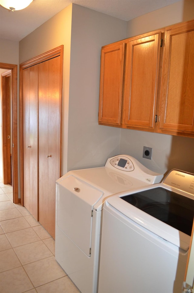 laundry area featuring cabinets, independent washer and dryer, and light tile patterned floors