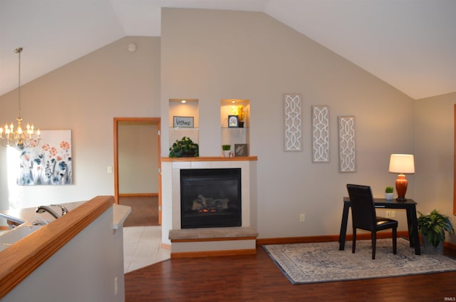 interior space featuring wood-type flooring, lofted ceiling, a fireplace, and a chandelier