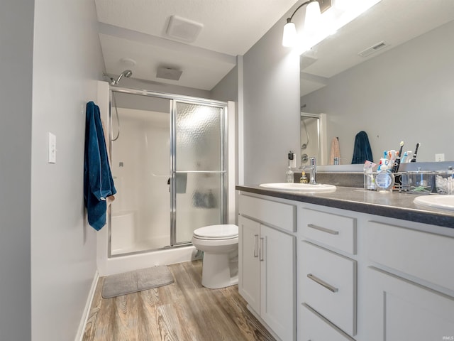 bathroom featuring hardwood / wood-style floors, vanity, toilet, and an enclosed shower