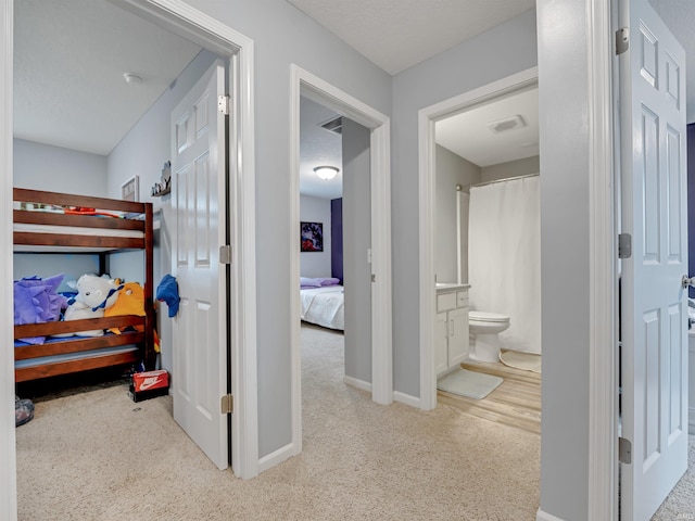 carpeted bedroom featuring ensuite bathroom