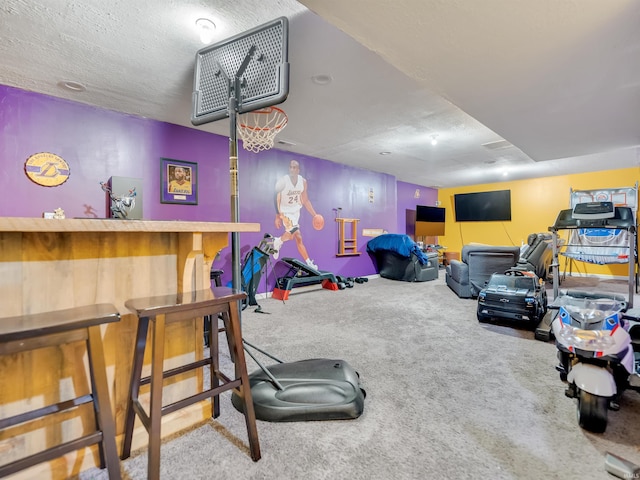 rec room with light carpet and a textured ceiling