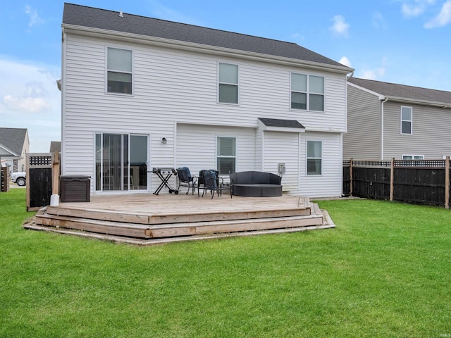 rear view of property featuring a wooden deck and a yard