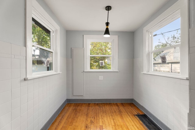 unfurnished dining area featuring tile walls