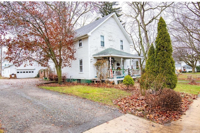 front of property featuring a porch, a garage, and a front lawn