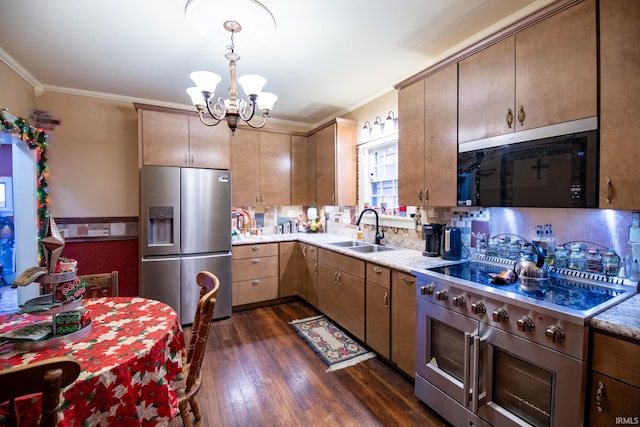 kitchen with appliances with stainless steel finishes, dark hardwood / wood-style flooring, ornamental molding, sink, and an inviting chandelier