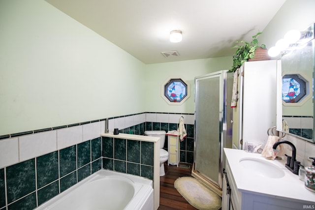 full bathroom featuring hardwood / wood-style floors, toilet, vanity, independent shower and bath, and tile walls