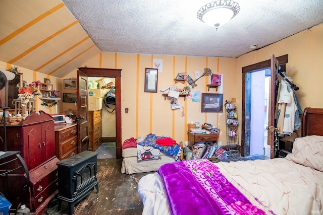 bedroom featuring a textured ceiling, a wood stove, and lofted ceiling