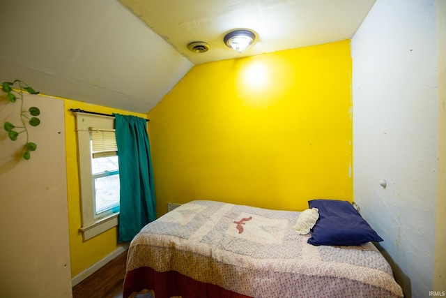 bedroom with hardwood / wood-style flooring and lofted ceiling