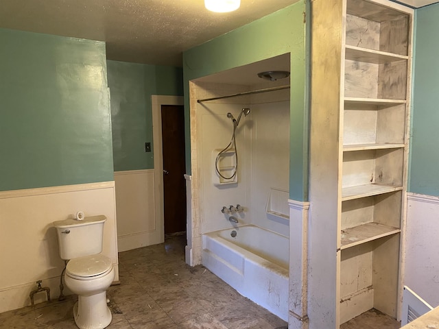 bathroom with shower / tub combination, a textured ceiling, and toilet