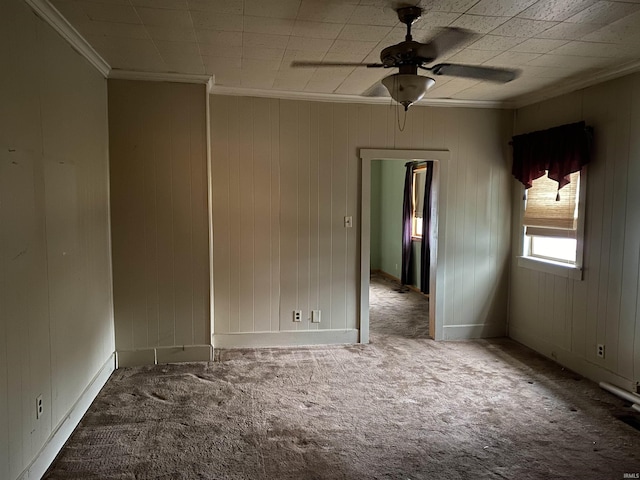 carpeted empty room featuring ceiling fan and crown molding