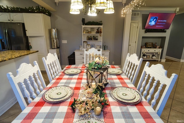 tiled dining room with an inviting chandelier