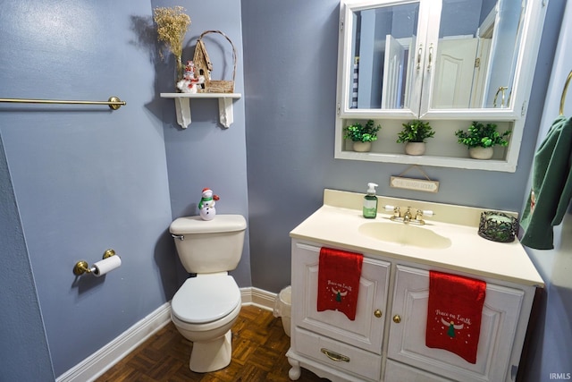 bathroom with parquet flooring, vanity, and toilet