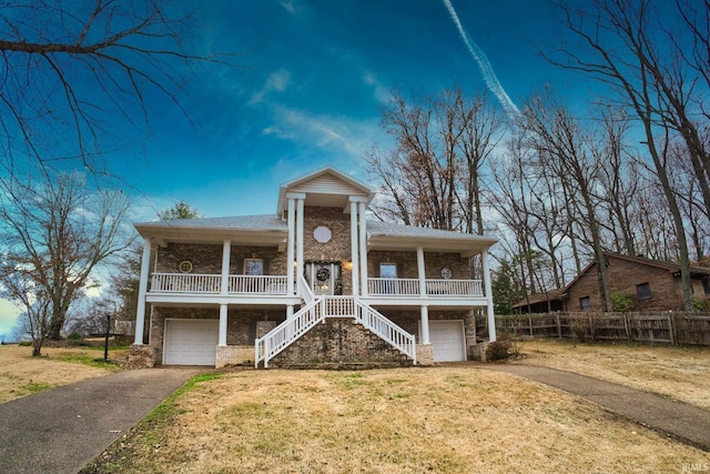 view of front facade with covered porch, a garage, and a front yard