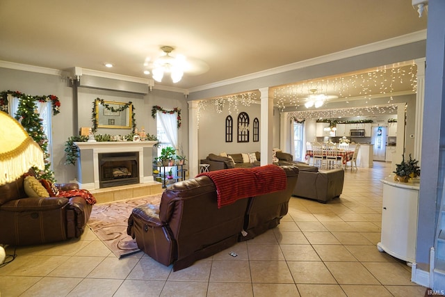 tiled living room featuring a tile fireplace, ceiling fan, and crown molding