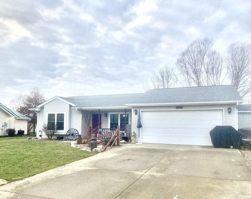 ranch-style house featuring covered porch, a garage, and a front lawn