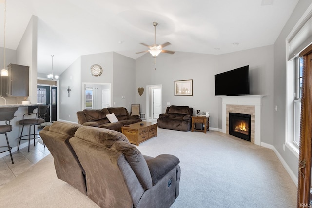 living room with a fireplace, light carpet, ceiling fan with notable chandelier, and vaulted ceiling