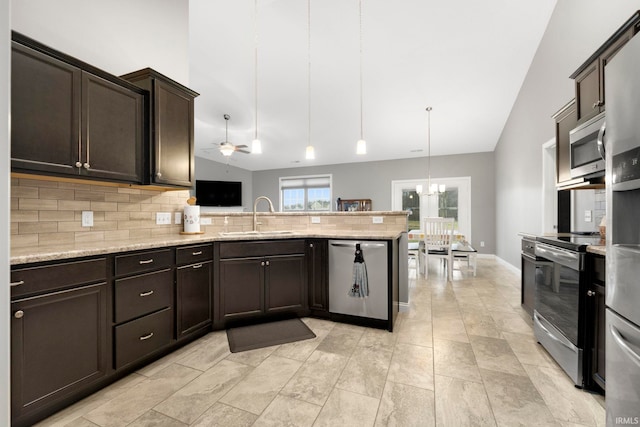 kitchen featuring ceiling fan with notable chandelier, sink, hanging light fixtures, tasteful backsplash, and stainless steel appliances