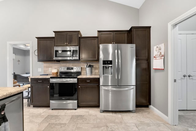 kitchen featuring tasteful backsplash, dark brown cabinetry, stainless steel appliances, and vaulted ceiling