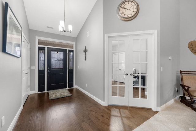 foyer entrance featuring a chandelier, hardwood / wood-style floors, vaulted ceiling, and french doors