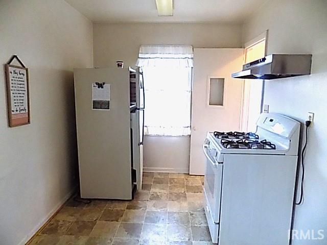 kitchen featuring white appliances and range hood