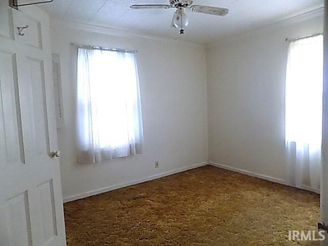 unfurnished room featuring ceiling fan and crown molding