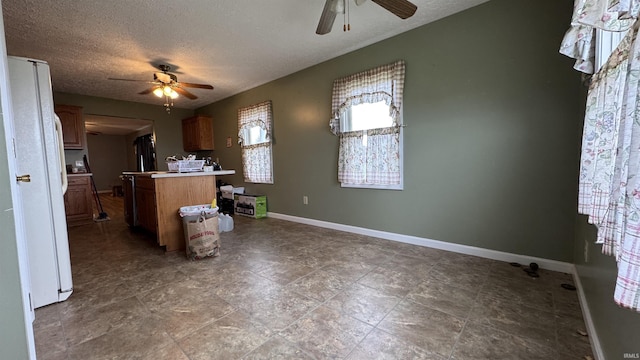 kitchen featuring a textured ceiling, ceiling fan, and white refrigerator