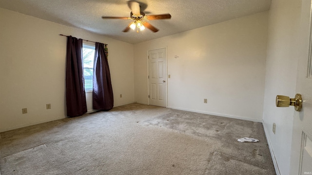 empty room featuring ceiling fan, light carpet, and a textured ceiling