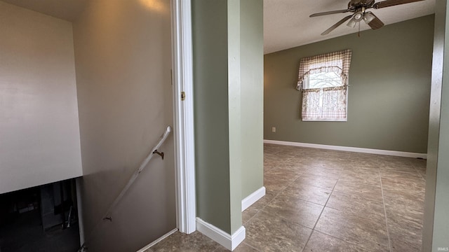 stairs featuring ceiling fan