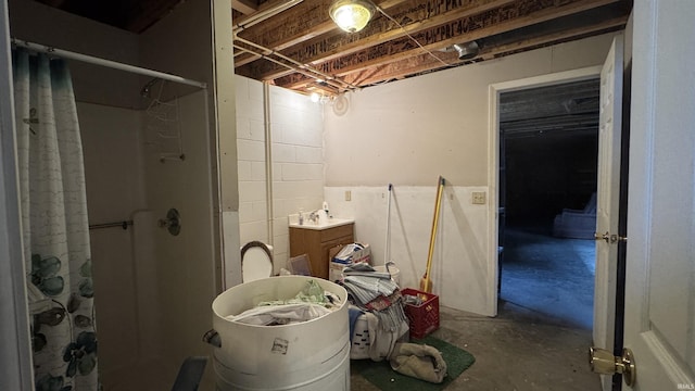 bathroom with curtained shower and concrete flooring