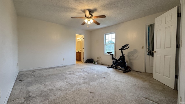 carpeted empty room with ceiling fan and a textured ceiling