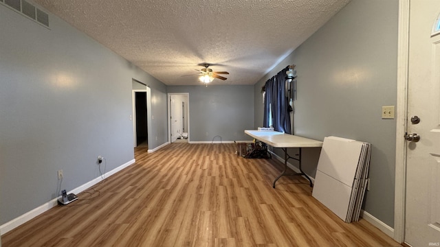 interior space featuring ceiling fan, light hardwood / wood-style floors, and a textured ceiling