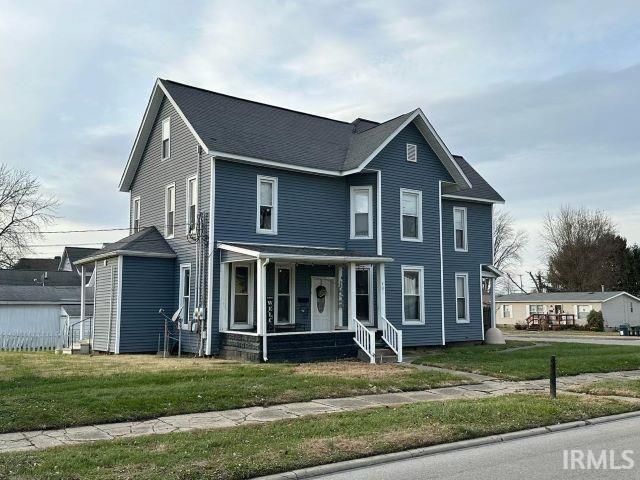 view of front of house with covered porch and a front yard