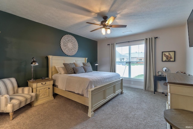 bedroom featuring ceiling fan, light carpet, and a textured ceiling