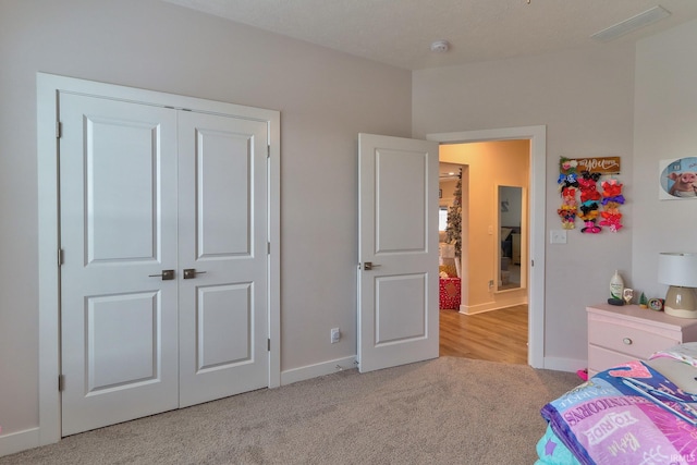 bedroom with light colored carpet and a closet