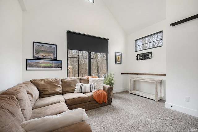 carpeted living room with high vaulted ceiling