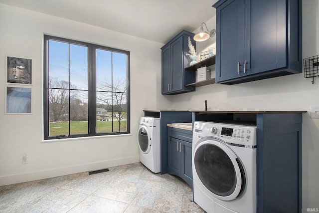 laundry area featuring washer and dryer and cabinets