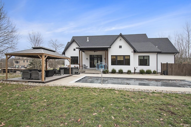 rear view of house featuring outdoor lounge area, ceiling fan, a yard, a covered pool, and a patio area