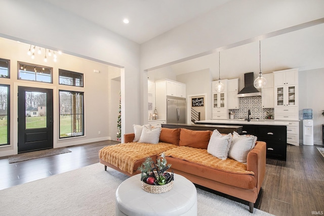 living room featuring dark hardwood / wood-style flooring, sink, and a high ceiling