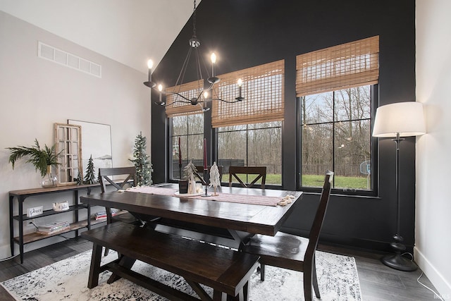 dining room featuring dark wood-type flooring and high vaulted ceiling